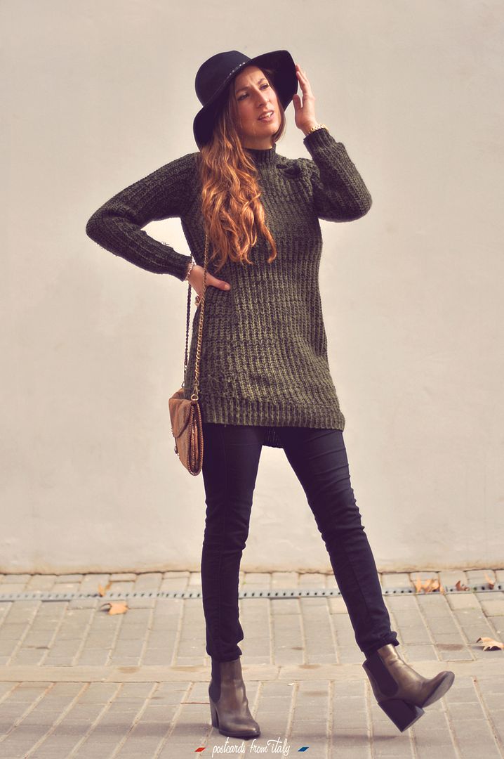 Outfit de jersei trenzado verde, sombrero negro y botines metalizados