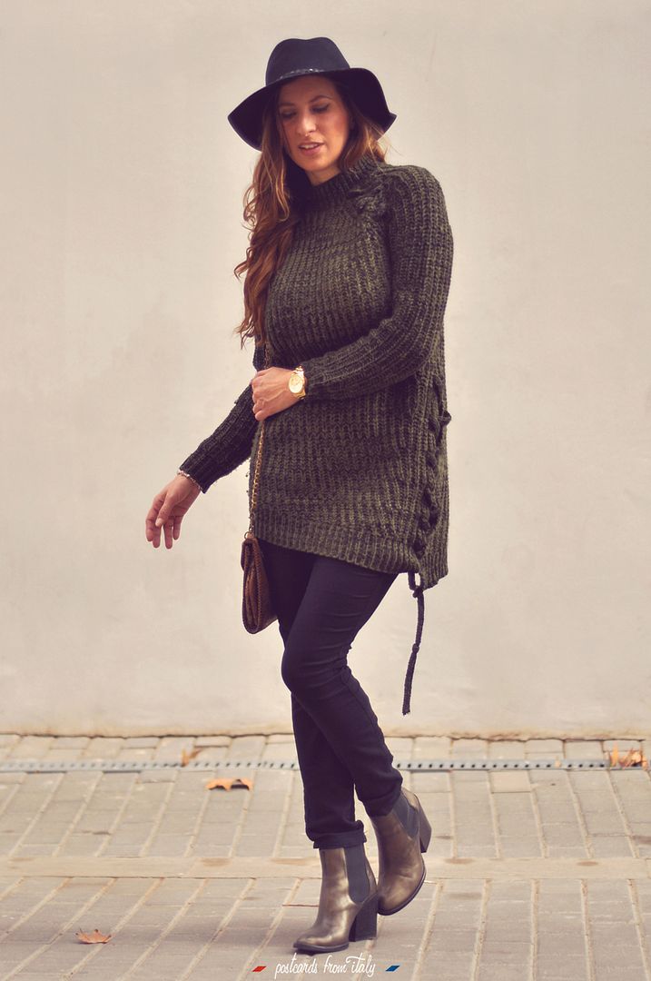 Outfit de jersei trenzado verde, sombrero negro y botines metalizados