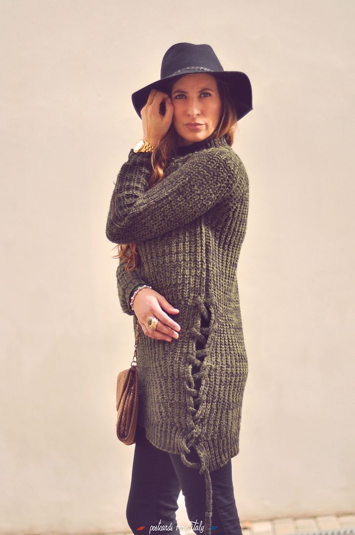 Outfit de jersei trenzado verde, sombrero negro y botines metalizados