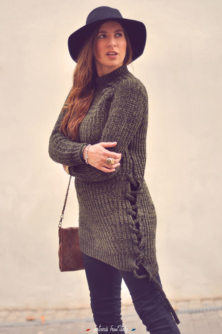 Outfit de jersei trenzado verde, sombrero negro y botines metalizados